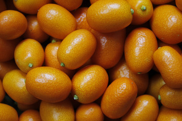 Kumquats Top view in the organic food market. Summer fruit background