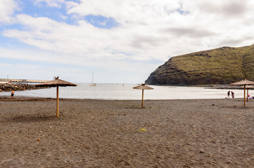 Black sand beach with a beautiful sky practically deserted in San Sebastian de la Gomera. April 15, 2019. La Gomera, Santa Cruz de Tenerife Spain Africa. Travel Tourism Photography Nature.
