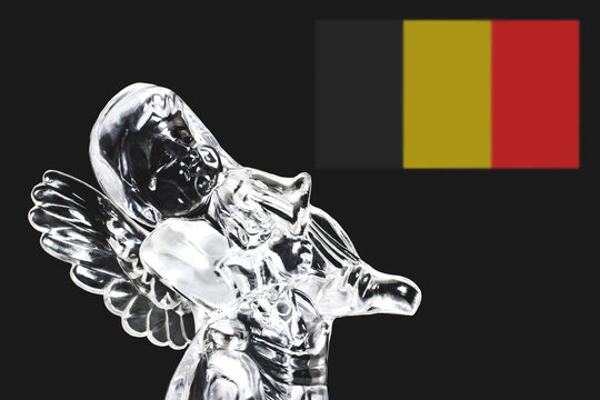 The photo of an angel with a tear in his eyes symbolizes grief and loss about the tragedy that happened. In the background is the Belgium flag, which is defocused and there is a place under copy space