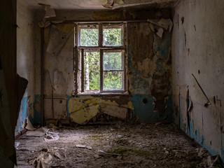 An abandoned room with dirty walls, broken window and trash on the floor, a sunny forest on the outside