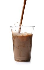 Pouring of coffee in cup with ice cubes on white background