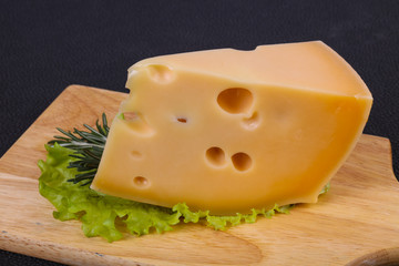 Maasdam cheese  in the board served salad leaves