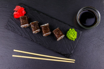 Sushi maki rolls with tuna on black slate. Top view