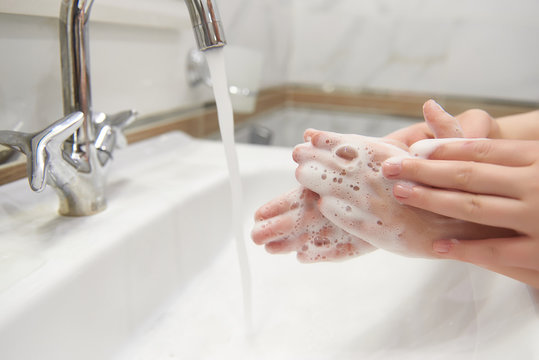 Cropped image of little boy and his mother washing hands with soap - Powered by Adobe