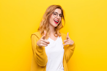 young pretty blonde woman smiling with a positive, successful, happy attitude pointing to the...