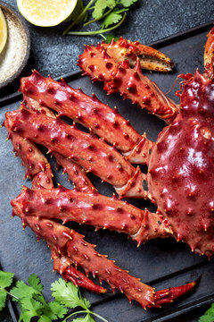 King Crab with lemon and cilantro on black background. Top view