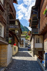 Street and typical wooden chalets in Zermatt village by day, Switzerland