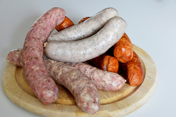 various types of sausages for cooking and baking on a wooden board