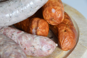 various types of sausages for cooking and baking on a wooden board