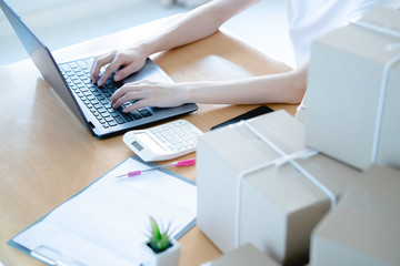 Online shopping young start small business in a cardboard box at work. The seller prepares the delivery box for the customer,