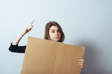 girl looks out from behind a cardboard paper