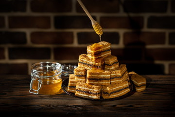 Plate with slices of honey cake and jar