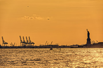 Water traffic on the Hudson River around Statue of Liberty at sunset, New York