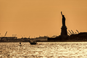Water traffic on the Hudson River around Statue of Liberty at sunset, New York