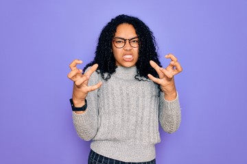 Young african american woman wearing casual sweater and glasses over purple background Shouting frustrated with rage, hands trying to strangle, yelling mad