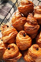 Freshly backed french traditional pastry - chocolate croissants shiny in the rays of the sun.
