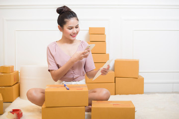 a woman is preparing products with cardboard boxes for shipping.