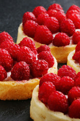 raspberries tart on the table. Fruit raspberry tart cakes on a black table.