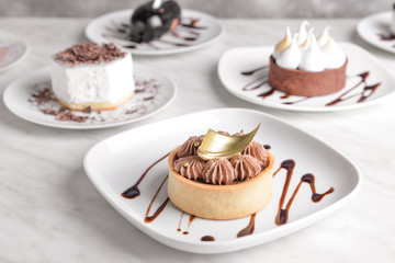 Plate with tasty cake on white table