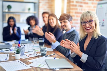 Group of business workers smiling happy and confident. Working together with smile on face looking at the camera applauding at the office