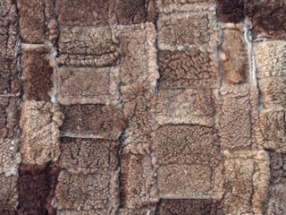 Brown background of rectangles of various sizes and shades, fur texture, close-up. Abstract, creative background in dark colors.