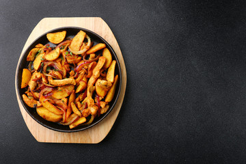 frying pan with potatoes meat and roast onion on black concrete background. mexican food concept. potatoes fried in a pan