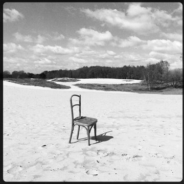 Lone Chair On Shore Against Clouds