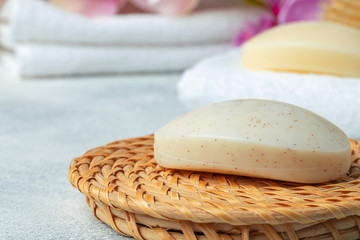 Fototapeta na wymiar Bar of natural handmade soap, towel and spa objects, close up