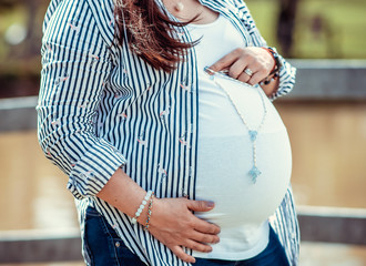 pregnant woman holding a rosary on her tummy