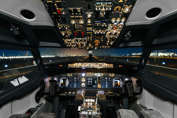 Full view of cockpit modern Boeing aircraft before take-off. Airplane is ready to fly. Night shot in cabin. Safety flight - obrazy, fototapety, plakaty