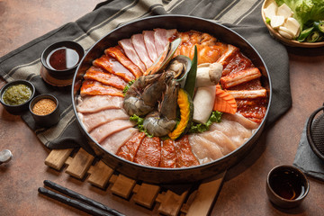 Sukiyaki Japanese food shabu shabu. many kind of fresh raw beef and pork, shrimp, shell with sauce dip and vegetable, mushroom, garlic in Japanese's style