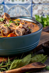 Beef ribs Bourguignonne in blue casserole. Homemade beef stew with vegetables and red wine