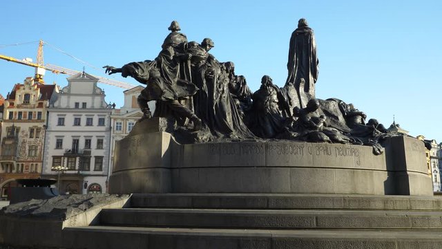 Jan Hus statue at Old Town square historical center of Prague in Czechia.  Movement reveals Old Town Square and Astronomical clock tower.