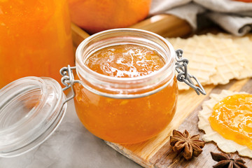 Jar of orange jam with wafers on table