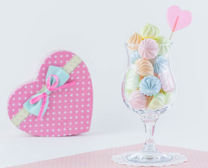 Multi-colored marshmallows lies in a glass. Gift box in the shape of a heart. Concepts of love.