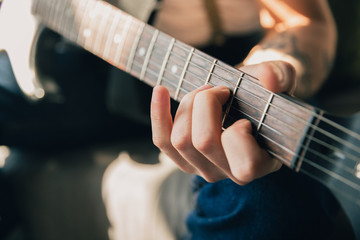 Fototapeta na wymiar Man studying at home during online courses or free information by hisself. Becomes musician, guitarist while isolated, quarantine against coronavirus spreading. Using laptop, smartphone, headphones.