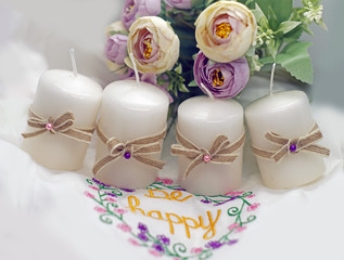white candles with bows on the flowers background
