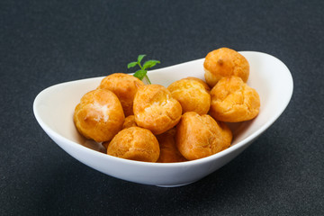 Sweet tasty profiteroles heap in the bowl
