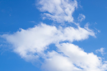 blue sky with torn clouds in places