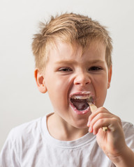 cute boy posing with bamboo toothbrush in his mouth, child brushes his teeth