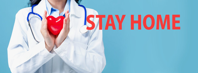 Stay home theme with a doctor holding a heart on a blue background
