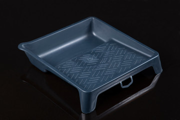 Bath for a paint roller on a black background.A tool to work with.