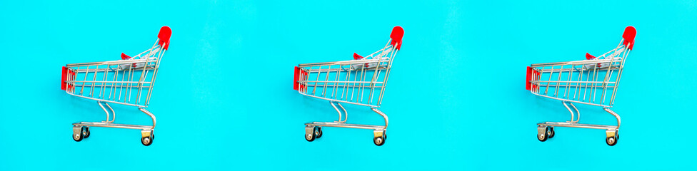 Basket on a blue background. Shopping cart in a supermarket. Sale, discount, shopaholism. Creative design. Banner.