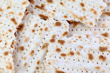 Matzo. Traditional jewish easter bread. Passover holiday symbol. Matzah broken, lies in a heap. With some free space for your text or sign. Close-up.