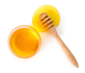 Jar of sweet honey and dipper on white background
