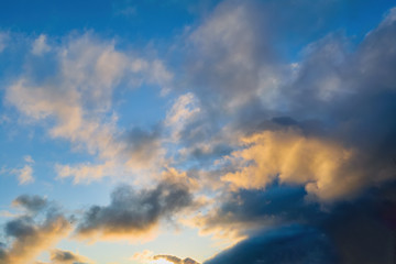 The sky at sunset. Cumulus clouds lit by the rays of the setting sun.