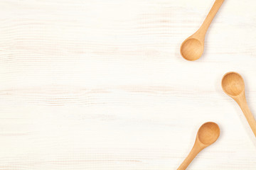 Wooden spoons on white table with copy space.