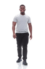 smiling young man striding forward. isolated on white