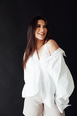 Portrait of a beautiful oriental fashionable brunette woman in a white shirt and shorts