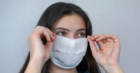 girl puts on medical face mask for safety anti virus